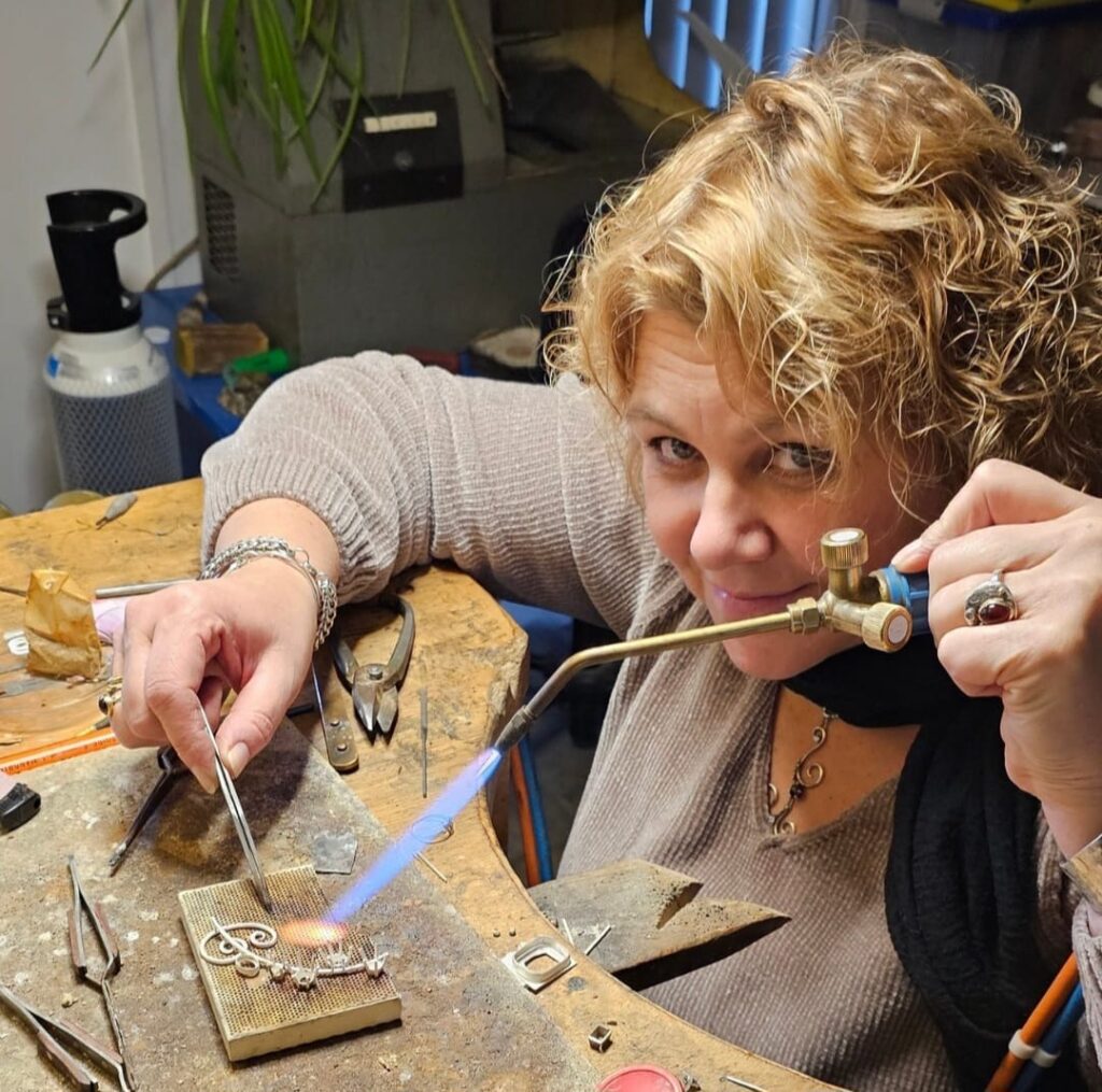 Goudsmid Esther Helena aan het werk met brander